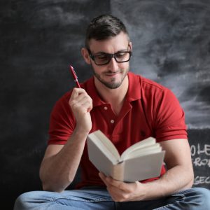 man-in-red-polo-shirt-and-blue-denim-jeans-holding-red-pen-3779488